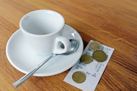 Foto: Kaffeetasse mit Rechnung und Münzen